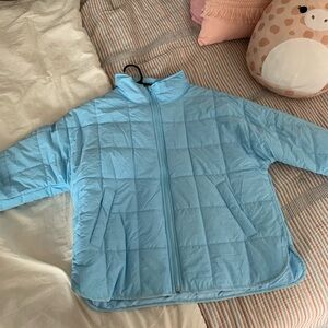 This is a sky blue puffer coat with pockets.